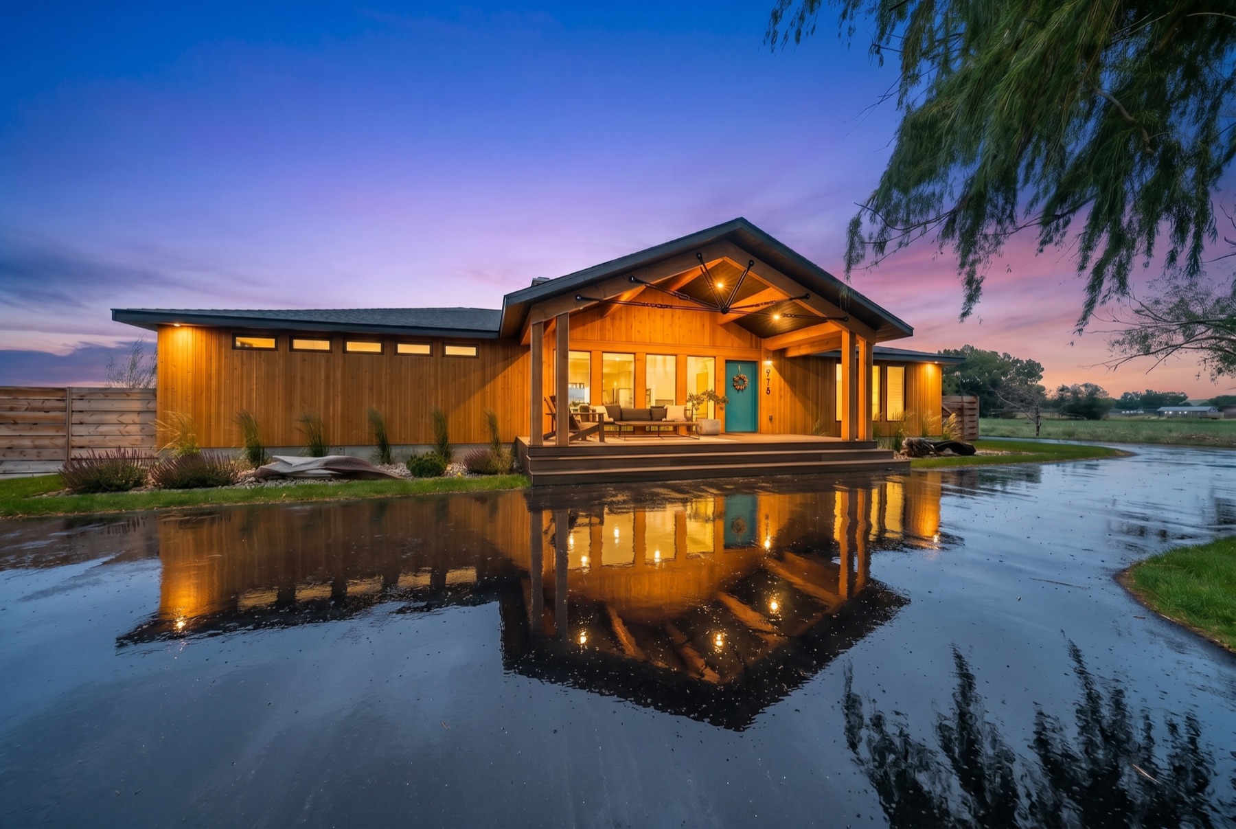 Modern home at twilight reflected in a wet driveway
