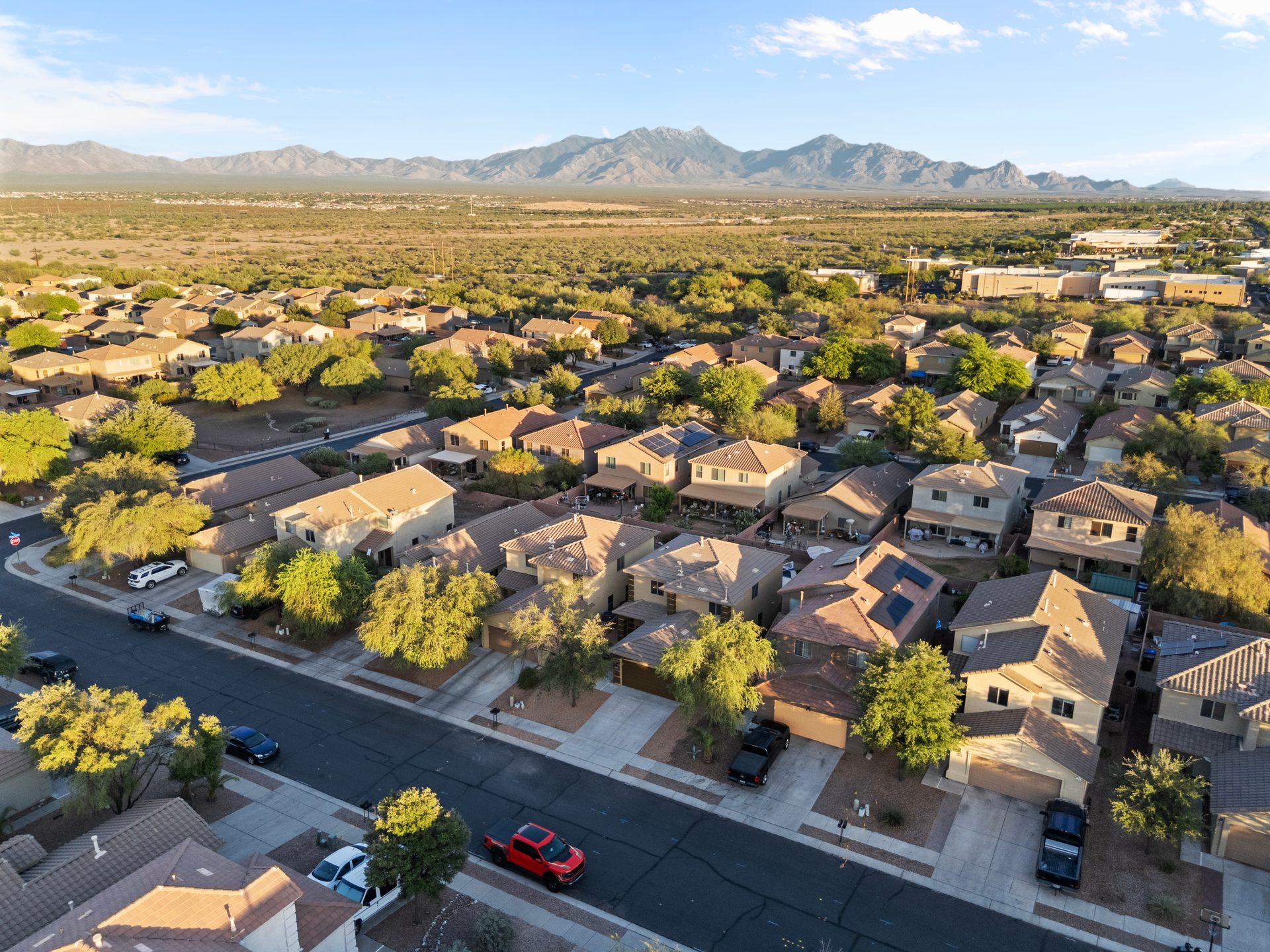 Golden-hour drone aerial of a property and the surrounding landscape